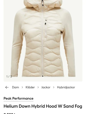 Peak Performance helium beige pufferjacka dam - Snygg beige pufferjacka från Peak Performance med huva och hel dragkedja. Jackan är lätt vadderad med dun och har slimmad passform samt quiltat mönster framtill och baktill. Perfekt för kalla vinterdagar och har en modern, sportig look. Xl men funkar som L