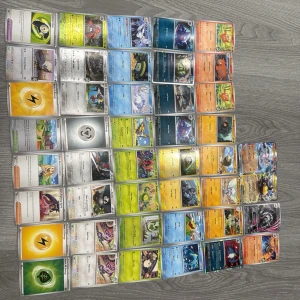 Stort paket Pokémonkort blandade typer - Säljer ett stort paket med Pokémonkort i olika färger och motiv. Blandningen innehåller både energikort, tränarkort och flera olika Pokémon från olika generationer. Korten har färgglada illustrationer och är av standardstorlek. Perfekt för samlare eller spelare som vill utöka sin samling.