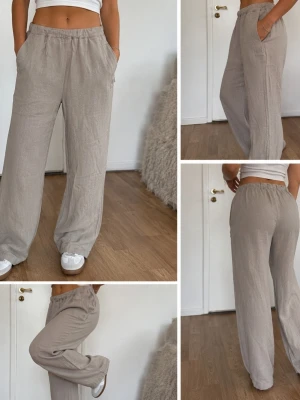 Beiga vida linnebyxor med resår - Snygga och bekväma linnebyxor i beige med bred passform och resår i midjan. Byxorna har sidofickor och är tillverkade i ett luftigt linnematerial, perfekta för en avslappnad stil. Passar till sneakers eller sandaler.