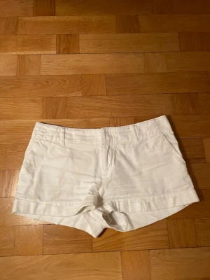 Vita shorts från Ralph Lauren - Snygga vita shorts från Ralph Lauren med lågmidja. De är gjorda av 100% bomull och därför perfekt för sommardagar. Klassisk design utan mönster eller extra detaljer utom logan på baksidan💕