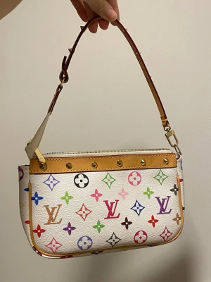 Pochette väska lv - Endast inspirerad. Perfekt accessoar för dig som vill sticka ut med färg och lyxig design. 