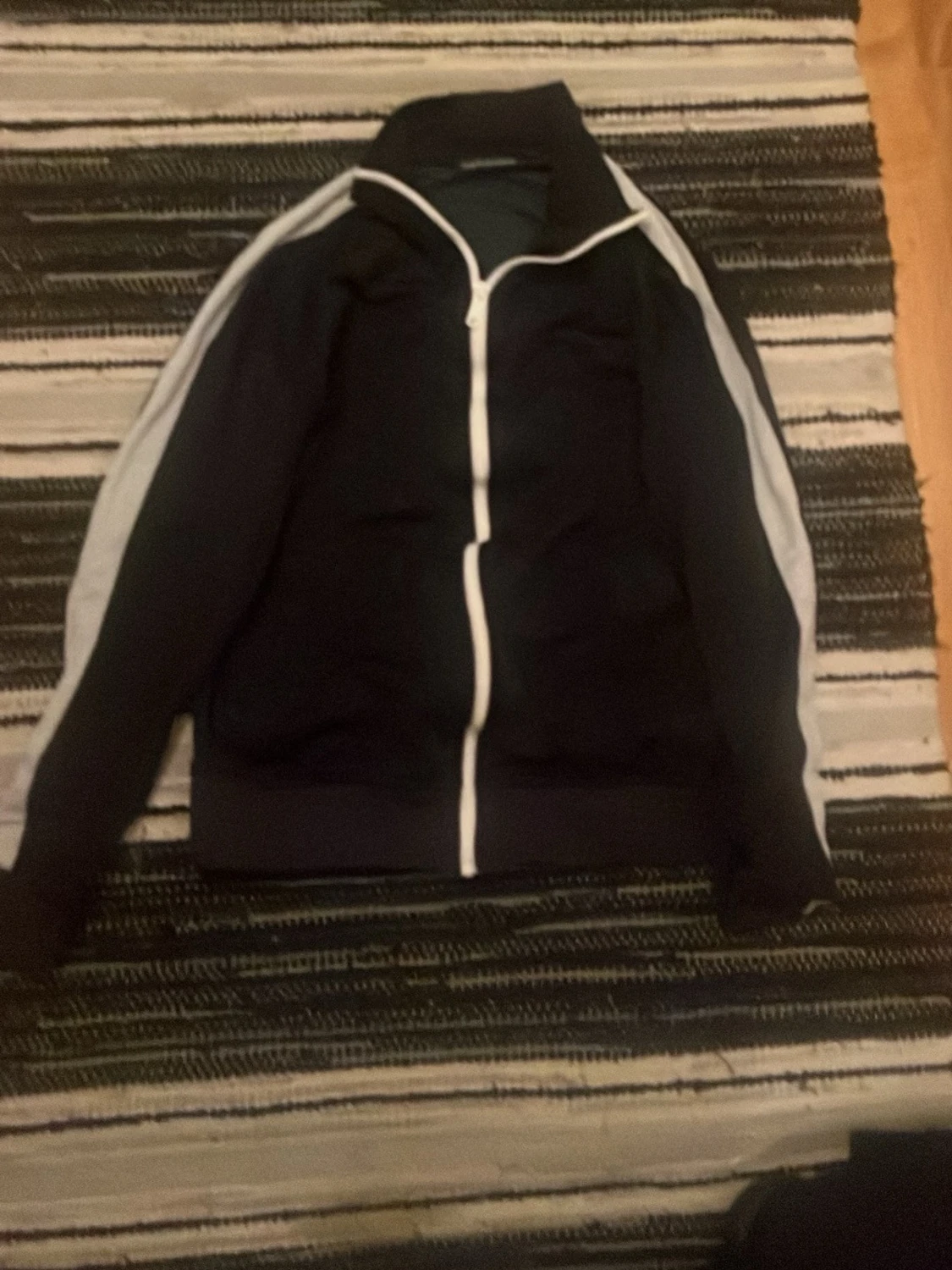 Svart vindjacka med vita detaljer