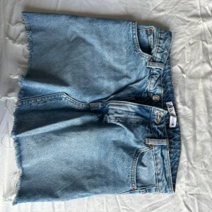 Lågmidjade jeanskjol - Säljer denna jeanskjol från Zara🩷, nypris 350kr💞pris går att diskutera! Den har ett litet ihop sytt hål på baksidan men det syns kanppt. Går jätte bra att fråga om mer bilder.