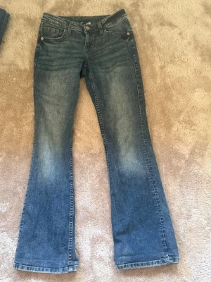 Blå lågmidja bootcut jeans från H&M, strl 36 - Lågmidja bootcut jeans från H&M