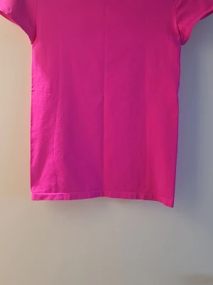 Rosa Träningstopp från Helmut Lang  - Träningdtröja i stretch. Färgen är riktigt poppig och ger en fräsch vibe till din outfit. Liten i storleken. Mjuk och superskön kvalitet.