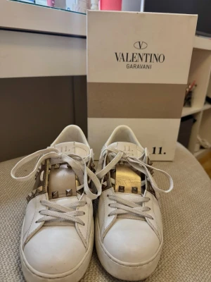 Valentino Garavani vita sneakers - Säljer ett par vita sneakers från Valentino Garavani med ikoniska nitar på sidorna. Skorna är i väldigt bra skick och har används i 2 månader. Jag säljer dessa för att kunna köpa något nytt. Om det prutas för mycket behåller jag hellre själv :) 💕💕💕
