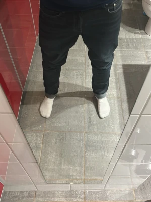 Svarta slim fit jeans - Säljer ett par svarta slim fit jeans med klassisk femficksmodell och uppvikta benslut. Jeansen har en snygg tvättad look och är tillverkade i stretchigt denimtyg som sitter skönt. Perfekta till en avslappnad stil. B: 112cm A: 43cm