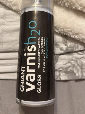 Ghiant Varnish h2o Gloss spray - Säljer en svart sprayflaska Ghiant Varnish h2o Gloss, vattenbaserat lack för konstnärer. Passar till olja och akrylfärg, ger glansig yta och innehåller 90% mindre lösningsmedel. Perfekt för att skydda och försegla målningar. Oanvänd.