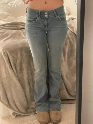 Intressekoll Low waist bootcut jeans  - Säljer dessa ljusblåa low waist bootcut jeans från Nelly.  Väldigt fint skick förutom lite slitna längst ner på byxorna. Två knappar och vanliga bakfickor. Säljs ej längre på hemsidan. Skriv om du har frågor! Sätter på köp nu ifall du tänkt köpa!