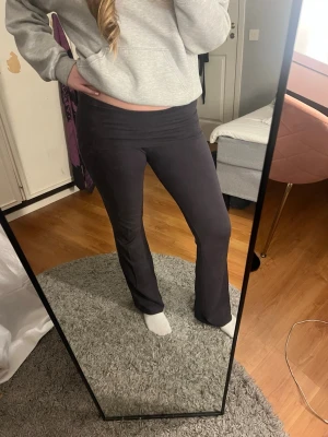 gråa yogapants - Gråa yogapants med bootcut-modell och vikbar midja. De är stretchiga och sitter skönt mot kroppen. Perfekta till en avslappnad look och passar till både hoodie och crop top.