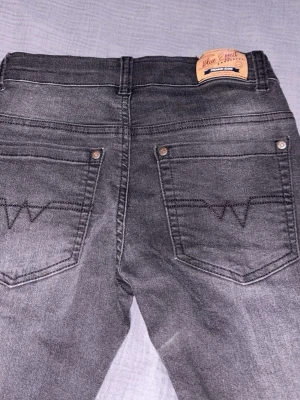 Svart jeans från Blue Effect - Snygga grå jeans från Blue Effect med klassisk femficksmodell och dekorativa sömmar på bakfickorna. Jeansen har normal passform och är tillverkade i mjukt bomullsmaterial med en liten stretch för extra komfort.