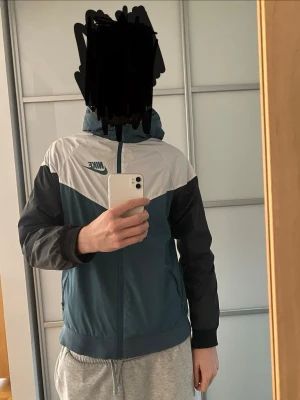 En vit, svart och grön ish vindjacka från Nike - Snygg vindjacka från Nike i helt nytt skick. Pris går att diskutera 