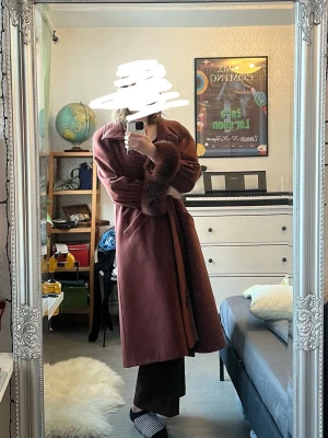 Rödbrun Kappa - En varm och mjuk ulkappa 85% ull 15% polamide. Låtsaspäls runt ärmarna men riktiga fickor! 😌Köpt second hand men helt oanvänd av mig då den är för stor. Uppskattningsvis strl L eller XL om man inte har för långa armar. 