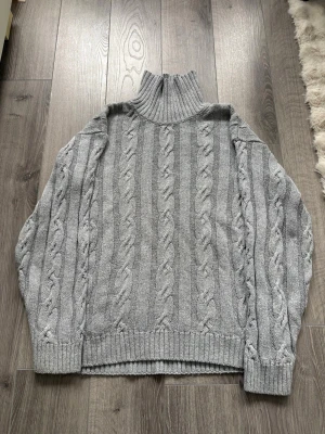 Grå kabelstickad  - Säljer denna snygga hoodien för bra pris. Den är väldigt snygg och passar till allt. Den är i väldigt bra skick. Jag skulle säga att det är storlek M. Hör av dig vid fundering!🤔