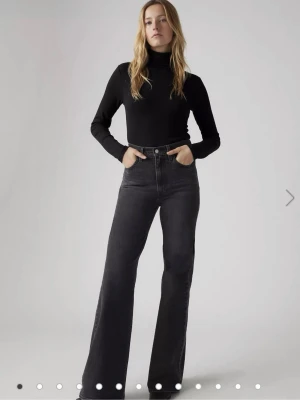 Svarta raka jeans med hög midja - Säljer ett par svarta jeans med hög midja. Jeansen har klassiska fem fickor och knappstängning framtill. Perfekt för dig som gillar en avslappnad och trendig look. Materialet är denim och färgen är mörkgrå/svart.