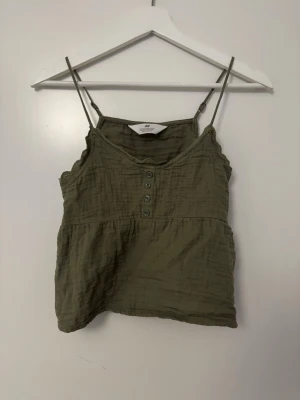 Olivgrön linnetopp från H&M - Säljer en söt olivgrön linnetopp från H&M💕 storlek 152 men är som en xs/xxs, jätte fin till sommaren!❣️