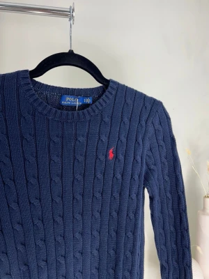 Ralph Lauren blå stickad tröja – preppy vibes & ikonisk logga ✨ - Blå stickad tröja från Ralph Lauren i superfint skick 💙  En tidlös och stilren tröja som passar till allt – jeans, kostymbyxor eller över en skjorta för en mer uppklädd look. Perfekt för dig som gillar preppy, old money eller clean aesthetic.  Mjuk och skön kvalitet med klassisk passform och den ikoniska broderade loggan framtill som ger en exklusiv känsla ✨  🧵 Stickad modell 💙 Djup blå färg 👌 Lätt att matcha ♻️ Perfekt second hand-fynd  Säljes då den inte kommer till användning.