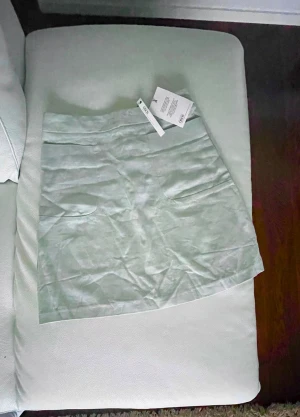 ASOS 🌿linnekjol 36/UK 8 - Ny ljus jadegrön kjol från ASOS i fin linne-viskos blandning. Storlek 36, UK 8, kolla kjolens mått här nedan. Oanvänd, lapparna kvar. Felfri. Två fickor framme, dragkedja baktill. Midjans omfång ca 66 cm Höftomfång 90 cm under fickorna Längd 44 cm