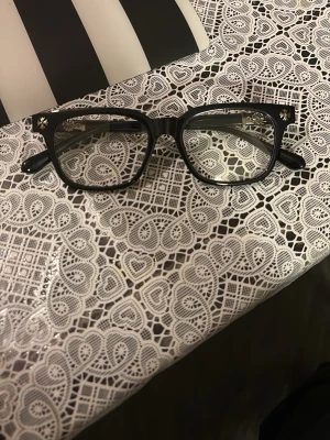 Svarta solglasögon med metallbåge - Säljer ett par stilrena svarta solglasögon med rektangulär form och metallbåge vid sidorna. Perfekt för dig som vill ha en klassisk look med en modern touch. Bågarna är i syntetmaterial och har silverfärgade detaljer vid gångjärnen.