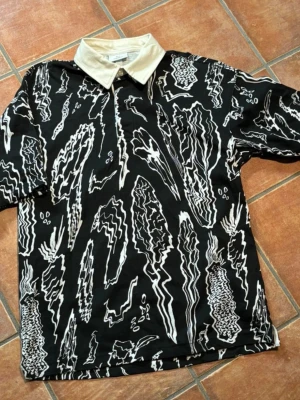 H&M short sleeve shirt - H&M Summer Vibe kortärmad skjorta i svart och vitt. Använd en gång, mycket bra skick. 1/3 knappar. Storlek XS.  H&M Summer Vibe stylish short-sleeve shirt in black and white. Oversized Fit Worn once, like new. 1/3 buttons. Size XS.