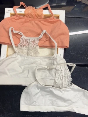 4 spetsbhar, 158/164 - Säljer fyra mjuka bhar i olika färger: svart, vit, grå och aprikos. Alla har spetsdetaljer framtill och tunna axelband. Perfekta för dig som gillar bekväma och snygga underkläder med en feminin touch. Materialet är bomullsmix med elastan för extra stretch. Strl: 158/164😀knappt använda, isåfall några få gånger! Alla 4 för 60kr