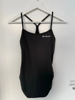 Träningstopp från SOC - Fin träningstopp från SOC med rynkdetalj i sidorna. Färgen ser lite mörkare ut på dom tre första bilderna, bild fyra ger mest rättvisa på färgen som är mörkgrå. Använd endast nån enstaka gång och är i väldigt fint skick.