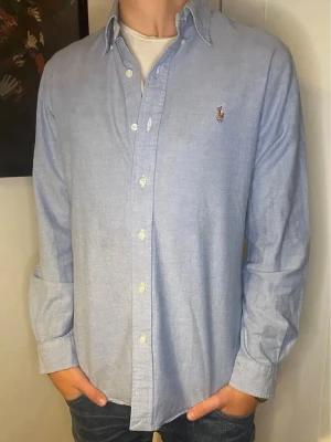 Ljusblå skjorta från Ralph Lauren - Säljer en fin ljusblå skjorta ifrån Ralph Lauren. Storleken är Medium och slimfit.  Inga defekter på tröjan och den är i fint skick. Modellen är 178 och väger 60kg. Hör av er vid eventuella frågor! 😊