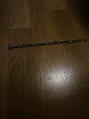 Cordell armband.  - Snyggt armband i guld pläterad färg  med flätad design. Armbandet har en robust karbinhake som lås och glänsande yta. Perfekt accessoar för dig som gillar stilrena och klassisk look. 7 mm 20 cm