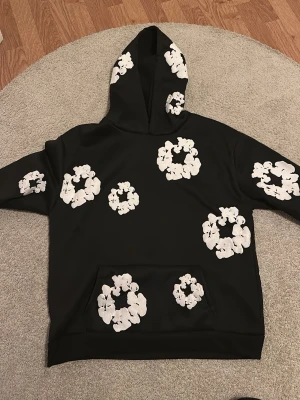 Svart hoodie med vita blommor - Bra hoddie som kallas för Denimtears Är stollek S fast är för stor i stolken och fungerar för M har använt 5 gånger MAX