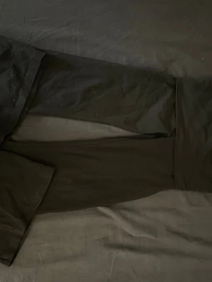 Svarta mjuka loungewear-byxor - Ett par svarta loungewear-byxor i mjukt och stretchigt tyg. Byxorna har resår och dragsko i midjan för extra komfort. Perfekta för att chilla hemma eller mysa runt i. Klassisk rak passform och helsvart design.