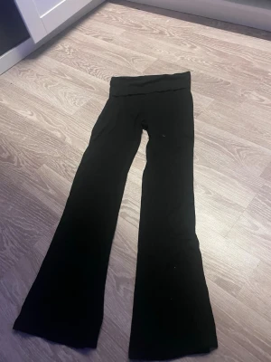 Svarta utsvängda leggings - Säljer ett par svarta leggings med utsvängda ben och hög midja. Perfekta för en avslappnad och trendig look. Mjukt och stretchigt material som sitter skönt hela dagen.