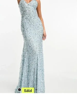 Ljusblå glittrig balklänning - Supersnygg ljusblå långklänning. Klänningen är täckt av glittriga paljetter och har en figurnära passform som faller snyggt mot kroppen. Perfekt för bal eller festliga tillfällen. Klänningen är helt ny med prislppar kvar. Köpt på asos. Märket är beauut.