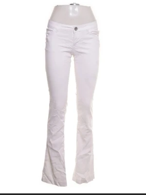 Vita bootcut jeans med låg midja - Snygga vita bootcut jeans med låg midja och klassisk femficksdesign. Jeansen har en knapp och dragkedja framtill samt utsvängda ben. Perfekta för en trendig och fräsch look.