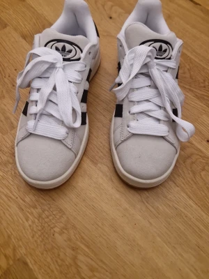 Adidas off white sneakers med svarta ränder - Helt oanvända, bara tagit ur förpackningen. Säljer för att de är för stora😊