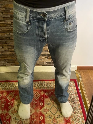 Ljusblå raka jeans  - Säljer ett par ljusblå jeans med raka ben. Jeansen har klassisk femficksdesign, bälteshällor och knappgylf. Perfekta för en avslappnad och trendig look.