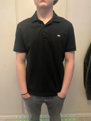 Lacoste piké - Stil ren svart piké från Lacoste. Inga defekter sitter bra och bekvämt.