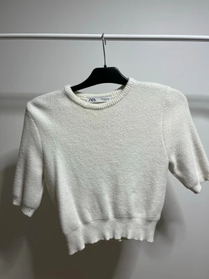 Vit stickad lite croppad topp från Zara - Väldigt mjuk vit stickad lite croppad topp från Zara, använt 1 gång o köpt begangnad, lite i storleken 