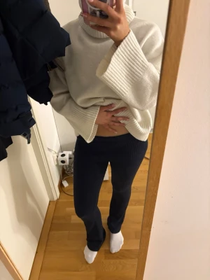 Mörkblå ribbade leggings - Säljer ett par mörkblå leggings med ribbad midja och stretchigt material. De har en tight passform och är perfekta för en avslappnad och trendig look. Passar dig som gillar bekväma men ändå snygga byxor.