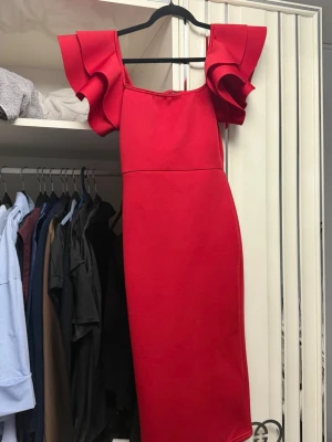 Röd off-shoulder klänning - Säljer denna oanvända klänning med volanger. Den är super fin och har en slits baktill. Storleken 40 men upplevarna någorlunda mindre❤️