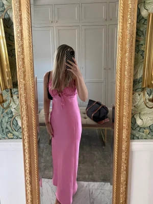 Rosa satin klänning med volangdetaljer Zara - Rosa klänning i satin med smala axelband och volangdetaljer vid bysten. 