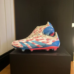 Fotbollskor - adidas predators 44 - Säljer nu ett par Adidas Predator fotbollsskor i vitt, rosa och blå. Jag väljer dessvärre att sälja dessa godingar då dom inte var rätt i storleken. Använde dom i drygt en vecka där jag hoppats på att kunna vänja mig, men jag hade köpt fel storlek. Skicket är nästan intill sprillans nytt, kan inte nämna en defekt. Köpta på Unisport för 3099kr. Hör gärna av dig vid frågor eller prisförslag!