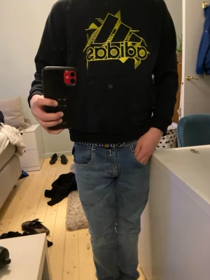 Svart hoodie från Adidas med gul logga - Svart hoodie från Adidas. Skön tröja att ha på sig. Säljer tröjan för att den är för liten. Hör av er vid minsta fundering!