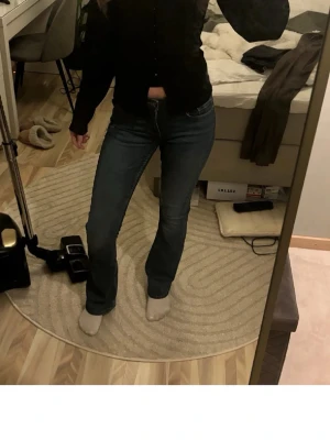 Mörkblå bootcut jeans - Säljer ett par mörkblå bootcut jeans med klassisk femficksdesign och normal midja. Jeansen har en snygg passform som framhäver benen och är perfekta till både sneakers och boots. Använda 2 ggr, så därav priset. Men kan diskuteras vid snabb affär 😊