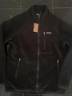 Ny Patagonia fleecejacka - Ny svart Patagonia fleecejacka i storlek L men passar M med
