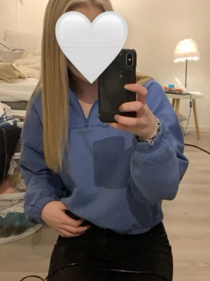 Blå halvzip hoodie från Weekday - Säljer en blå hoodie från Weekday med halv dragkedja framtill och avslappnad passform. Tröjan har elastiska muddar vid ärmslut och midja samt en hög krage. Perfekt för en snygg och trendig look. I storlek S💙