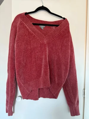 Vinröd stickad tröja med v-ringning - Mysig stickad tröja med v-ringning.