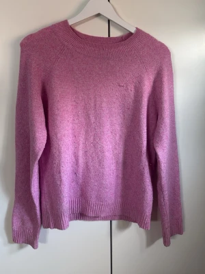 Ljusrosa stickad tröja - Mysig ljusrosa stickad tröja med rund halsringning och långa ärmar. Tröjan har ribbstickade muddar vid hals, ärmslut och nederkant. Perfekt för lager på lager och enkel att matcha med jeans eller kjol. Har haft ett litet hål i bröstet men är ihopsydd så syns knappt💗
