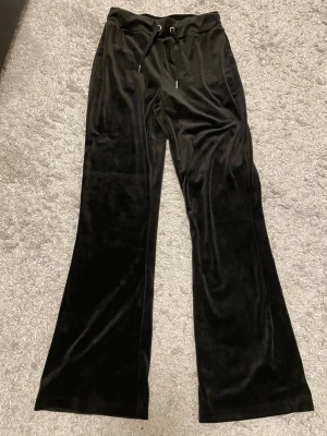 Supermysiga velour byxor från Gina Tricot - Svarta velourbyxor i mjukt och lyxigt material som ger en snygg glow-look. Trendig bootcut/flare-modell som sitter smickrande på benen. Bekväm resårmidja med snörning – både snyggt och skönt.  Har aldrig använt de så de är i mycket fint skick, inga fläckar eller defekter. Perfekta till både vardag, skola och mysiga outfits – kan stylas upp med topp och jacka eller ner med hoodie.  🖤 Stilrena 🖤 Bekväma 🖤 Trendiga 🖤 Lätta att matcha  Redo för ny ägare ✨