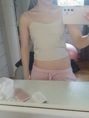 Beige linnetopp med smala axelband - Säljer en enkel och stilren beige linnetopp med smala axelband. Toppen är croppad och har en rak passform som är perfekt för varma dagar. Materialet känns mjukt och lätt, vilket gör den bekväm att bära. Perfekt att matcha med jeans eller shorts.