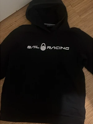 Svart hoodie från Sail Racing - Svart Sail racing hoodie köpt från kidsbrandstore nypris 800kr du får den för 200kr fraktar samma dag.
